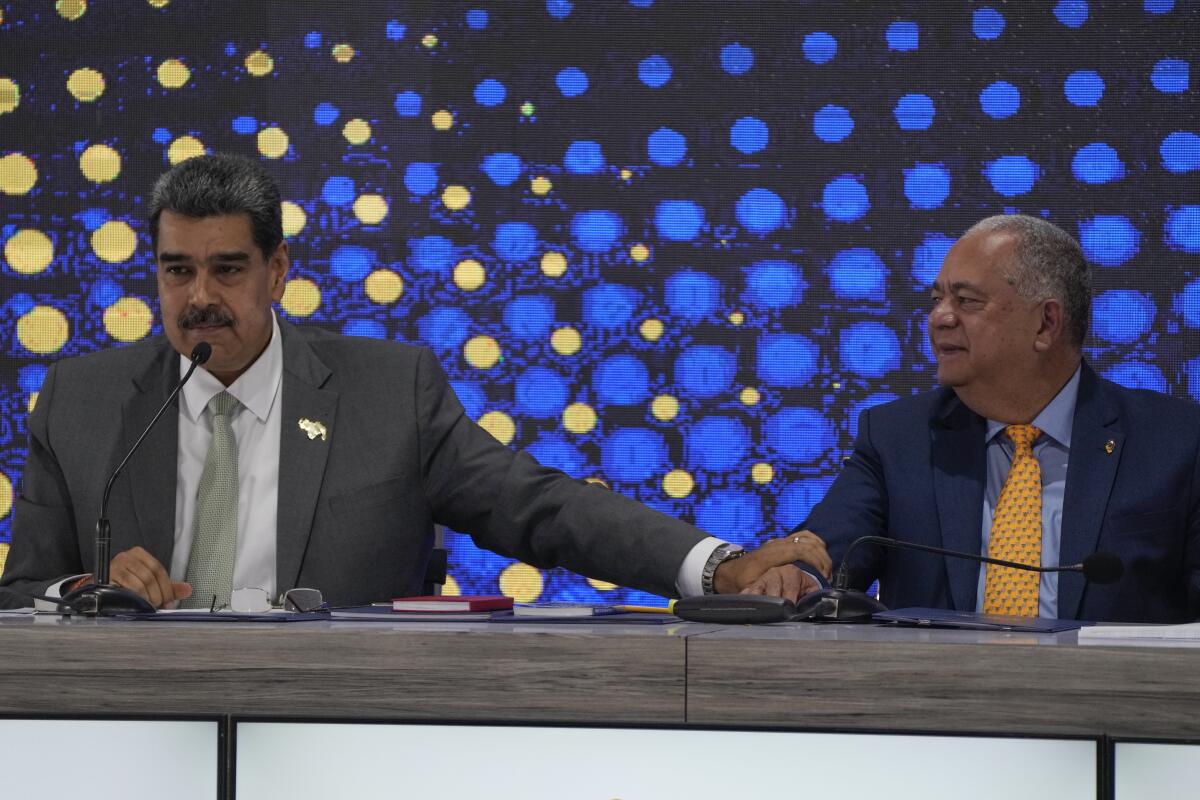 El presidente de Venezuela, Nicolás Maduro, a la izquierda, habla junto al presidente del Consejo Nacional Electoral