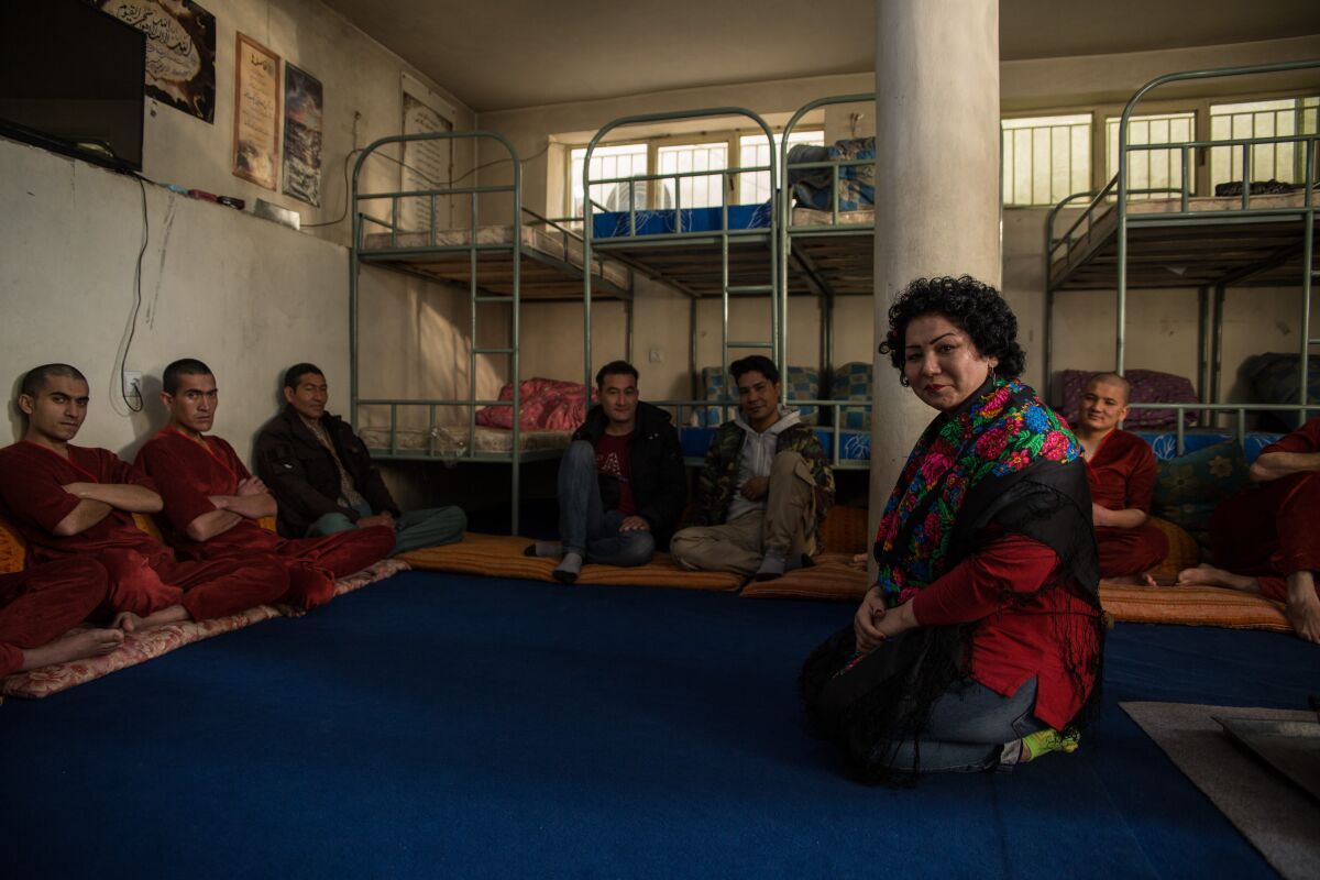 Laila Haidri sits with men at her drug shelter, Mother Camp