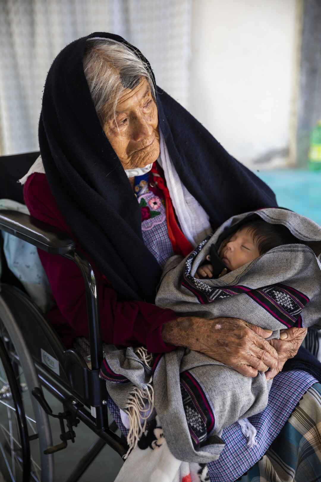 An older woman holds a tiny baby 