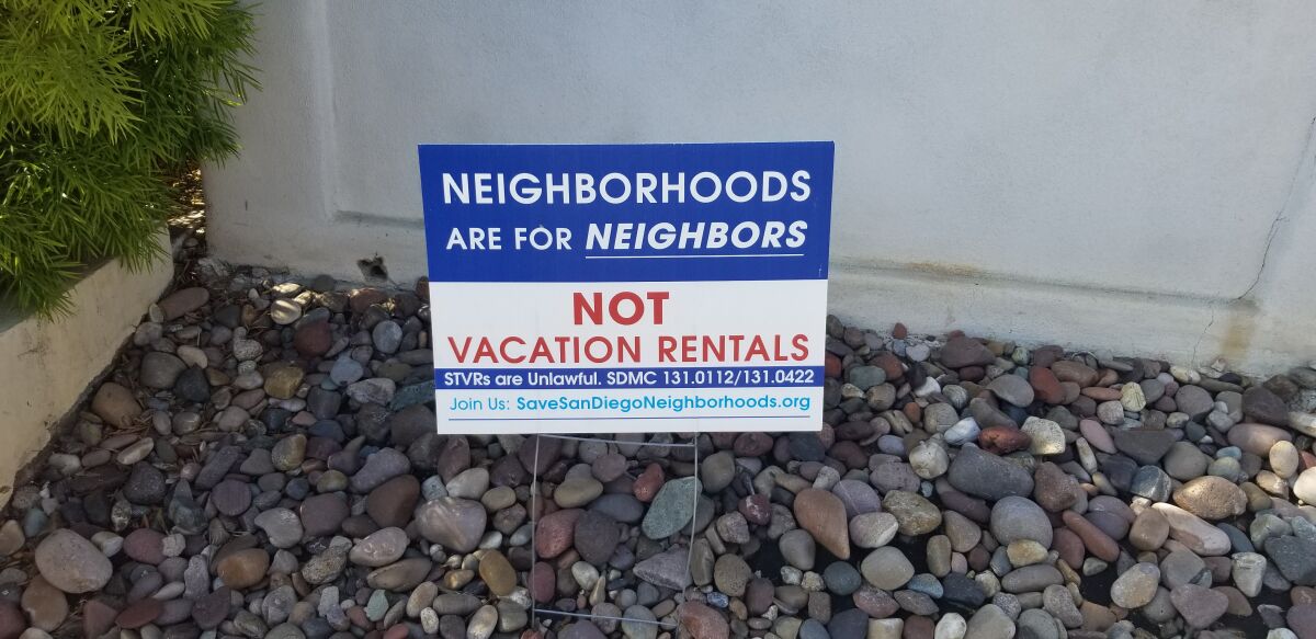 A sign in a yard in Pacific Beach reflects the feelings that many in the community have about short-term vacation rentals.