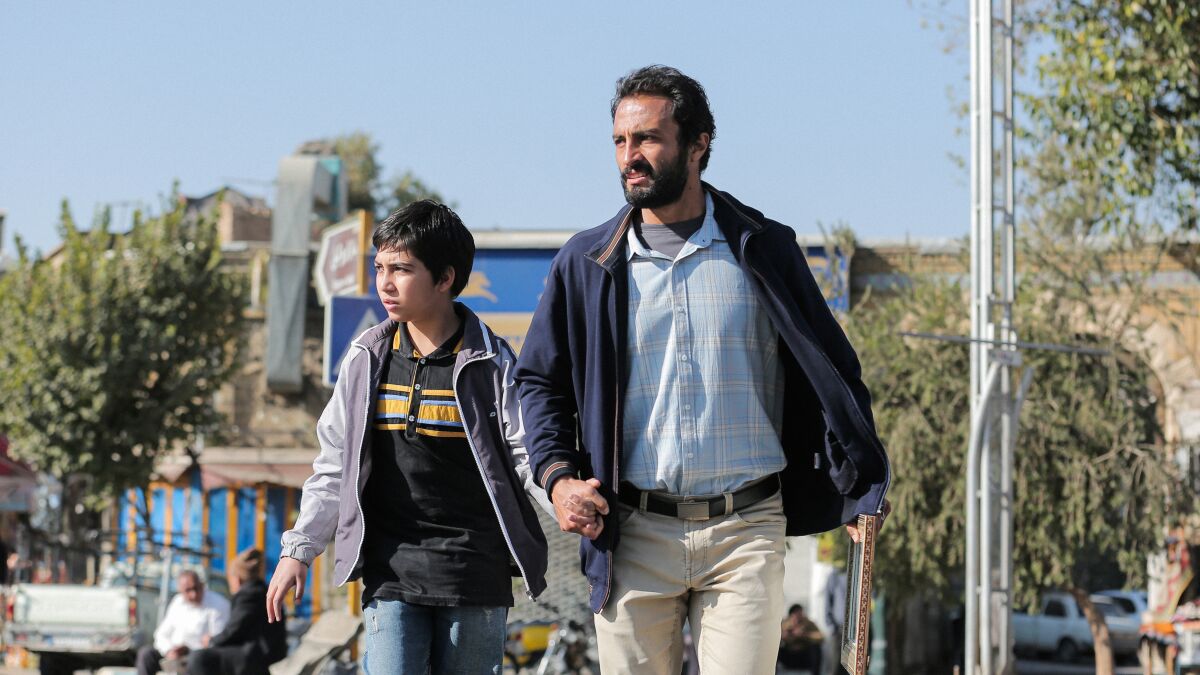 A man and a boy walk, holding hands