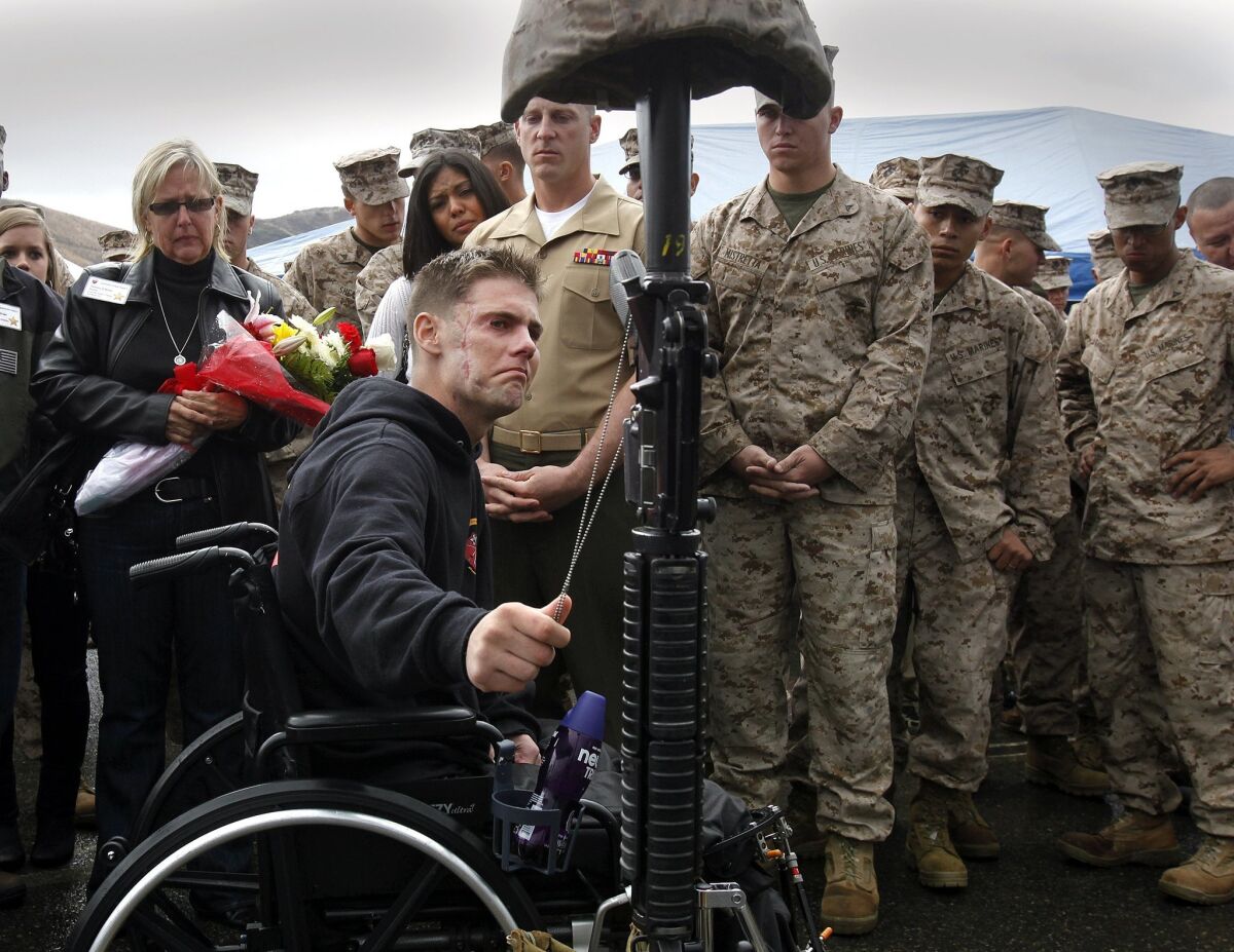 Lance Cpl. Cody Elliott pays his respects to fellow Marines killed in action. Elliott was severely injured in a bomb blast in Sangin, Afghanistan while running to help a fatally wounded Marine. — John Gastaldo / The San Diego Union-Tribune/Zuma