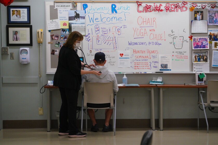 Julio Lara, 42, checks in with respiratory care practitioner Kathleen Kennedy to check his vital signs.