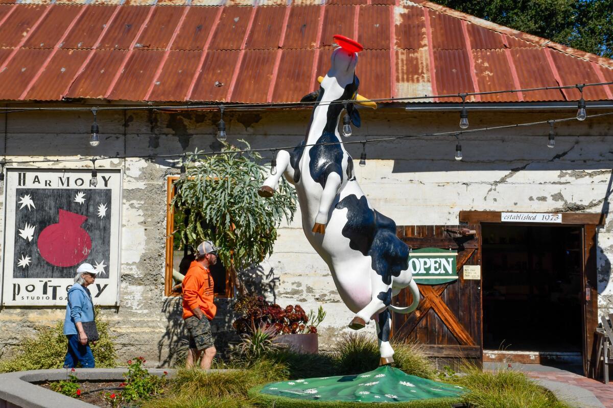 A cow statue in front of a building.