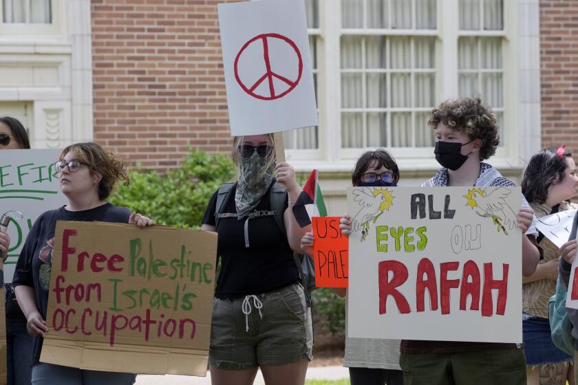 A small group of University of Southern Mississippi students and activists hold Pro-Palestinian signs protesting the Israel Hamas war in Gaza, during an hour-long silent vigil on the school's campus, Tuesday, May 7, 2024, in Hattiesburg, Miss. The 50 demonstrators drew no counter protesters or hecklers. (AP Photo/Rogelio V. Solis)