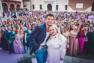 Stars Luke Newton and Nicola Coughlan pose before assembled "Bridgerton" fans at an event in Verona, Italy in May.