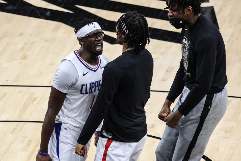 Monday, June 28, 2021, Phoenix, Arizona - LA Clippers guard Reggie Jackson (1) celebrates with teammates LA Clippers guard Terance Mann (14) and LA Clippers center Daniel Oturu (10) right late in the game as they defeat the Phoenix Suns in Game five of the NBA Western Conference Finals at Phoenix Suns Arena. (Robert Gauthier/Los Angeles Times)