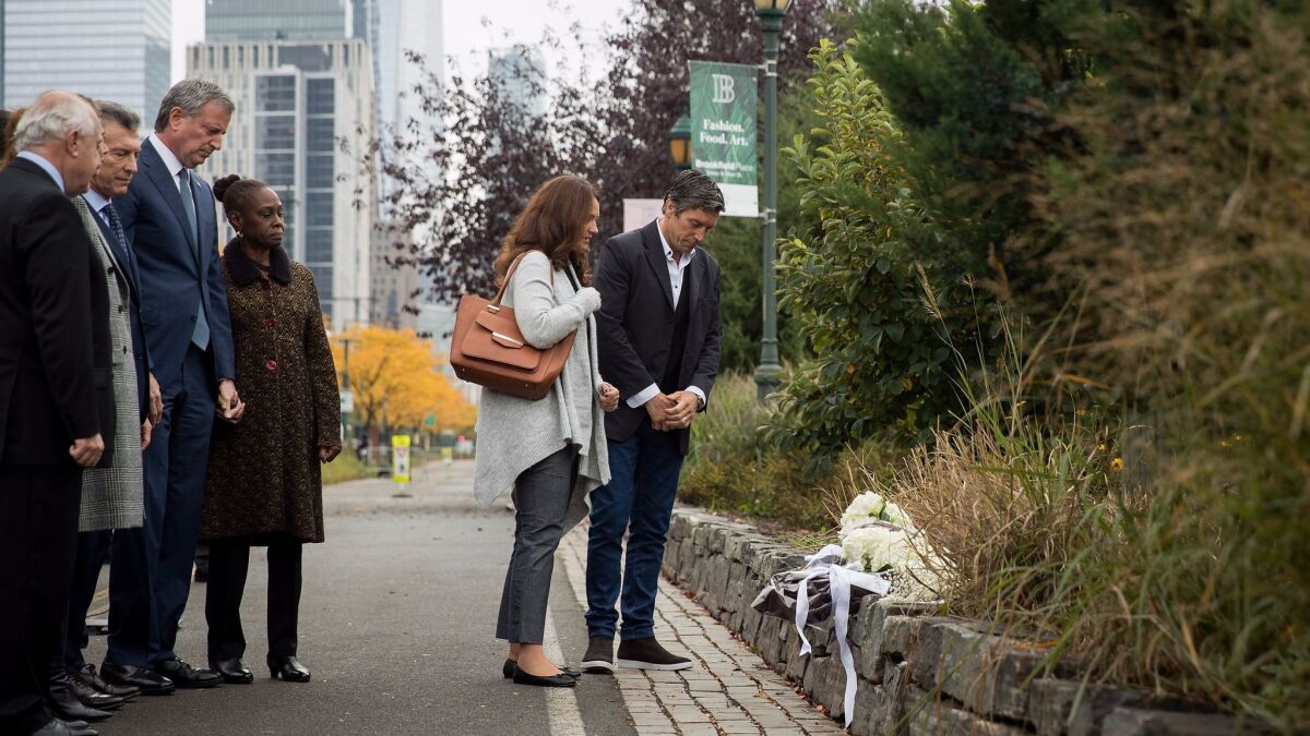ArgentinePresident Mauricio Macri, New York City Mayor Bill de Blasio and Chirlane McCray look as attack survivor Guillermo Banchini and a fellow mourner pause during a tribute for the victims of last week's bike path attack.