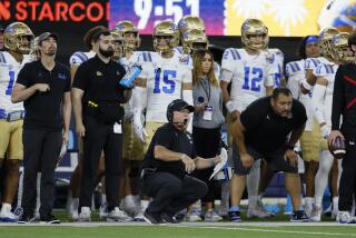 UCLA coach Chip Kelly crouches on the sideline reacts to a play during the LA Bowl against Boise State