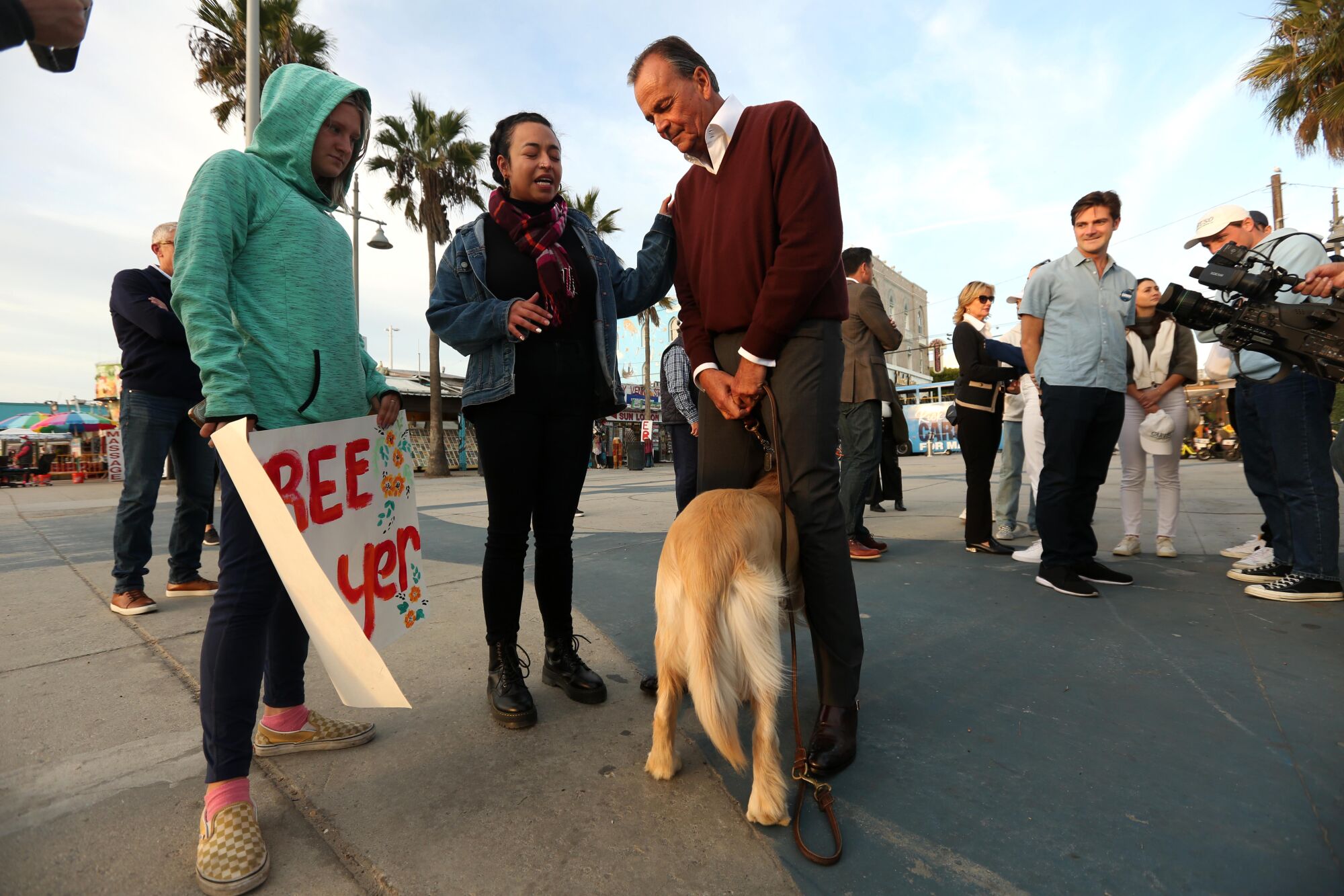 Two people with mayoral candidate Rick Caruso and a dog
