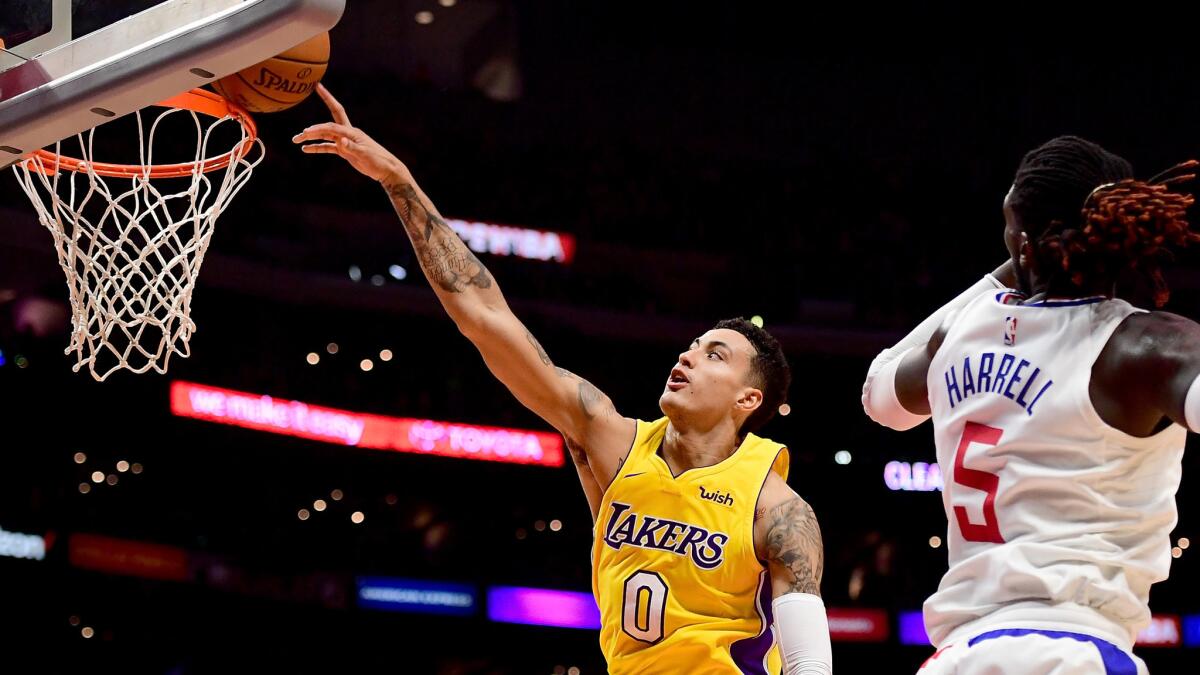 Lakers forward Kyle Kuzma is fouled by Clippers forward Montrezl Harrell during the season opener.