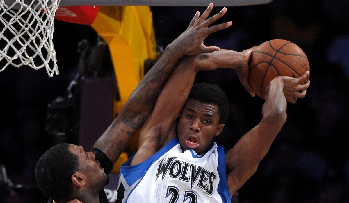 Timberwolves forward Andrew Wiggins tries to pass while under pressure from Lakers forward Tarik Black in the first half Friday night.