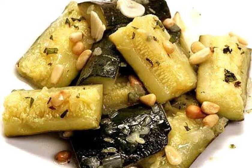 Zucchini with pine nuts are cooked to the texture of butter, tart with lemon and perfumed with fresh herbs.