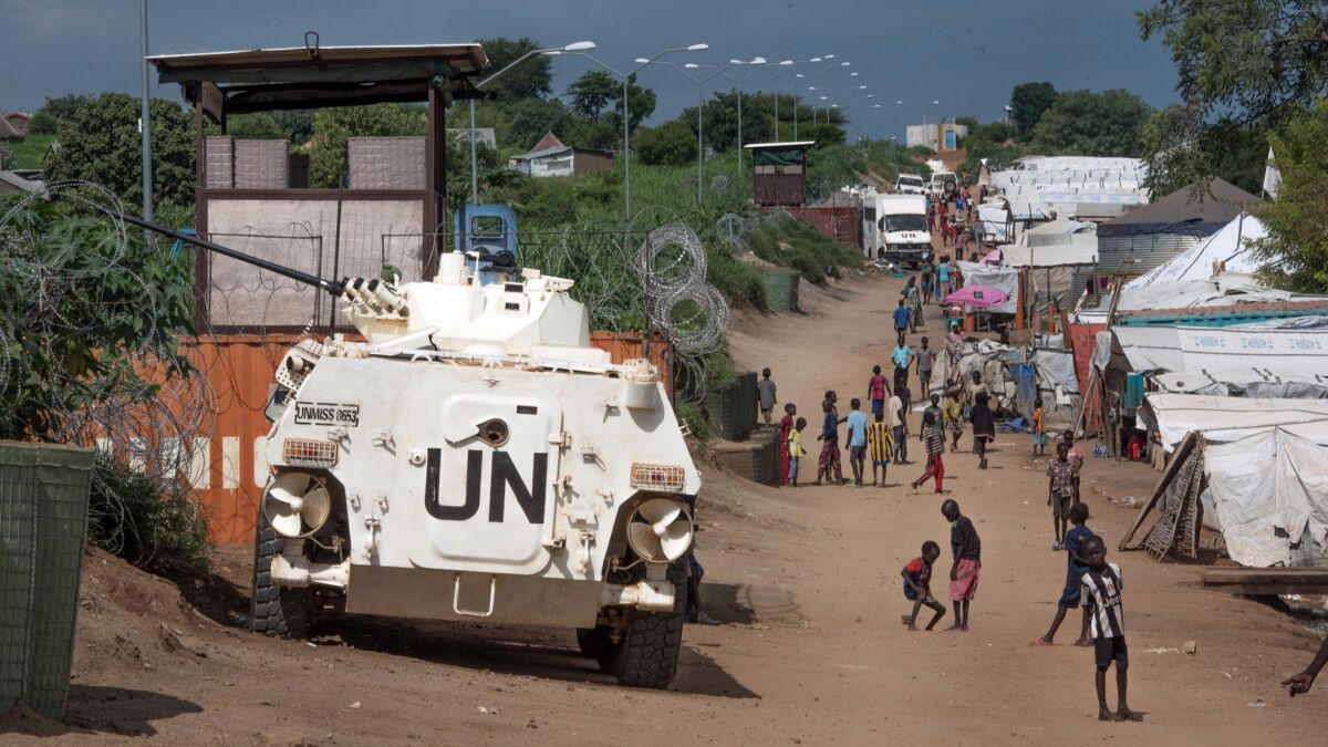 Some of the more than 30,000 Nuer civilians sheltering in a UN base in South Sudan's capital Juba for fear of targeted killings by government forces walk by an armored vehicle and a watchtower manned by Chinese peacekeepers on July 25.