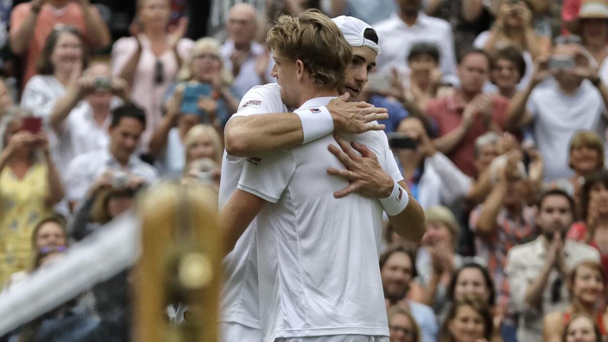 South Africa's Kevin Anderson, left, hugs John Isner of the U.S. after their marathon Wimbledon semifinal match.