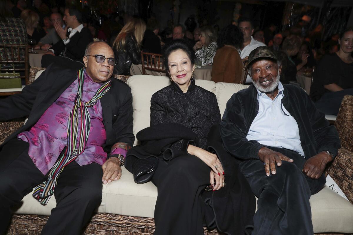 Quincy Jones, Jacqueline Avant and Clarence Avant sit side by side on a couch
