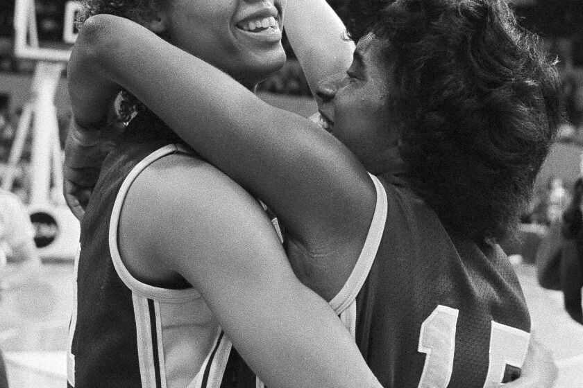 Cheryl Miller, left, of the University of Southern California gest a hug from teammate Juliette Robinson after they defeated the University of Georgia to move to the final game of the NCAA women's basketball tournament, in Norfolk, Va., Friday night, Apirl 1, 1983. (AP Photo/Bob Bryant)