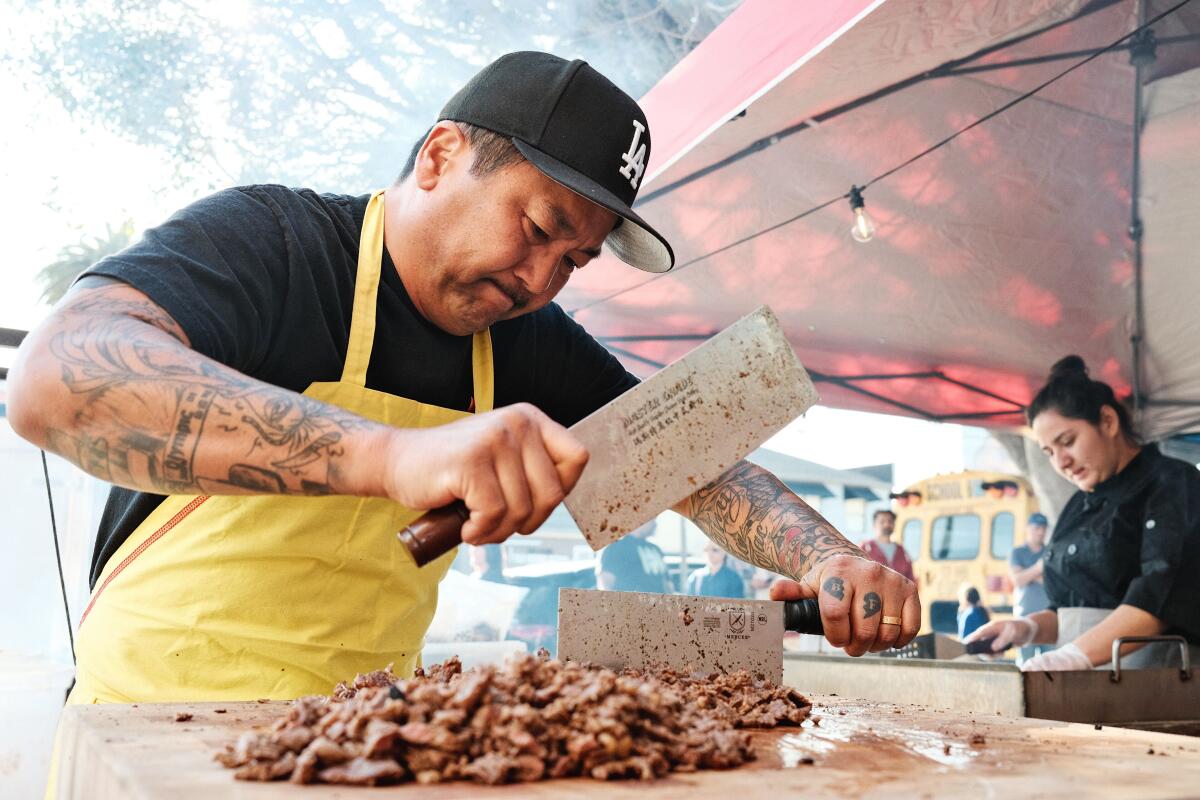 Kogi founder Roy Choi uses a cleaver to prepare al pastor at a street taco stand.