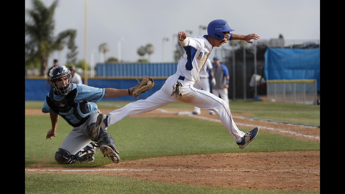 Fountain Valley High's Jake Bitzer, right, is tripped up by Crescenta Valley catcher Brian Ghattas as he scores a run during the sixth inning in the second round of the CIF Southern Section Division 2 playoffs on Tuesday, May 22.