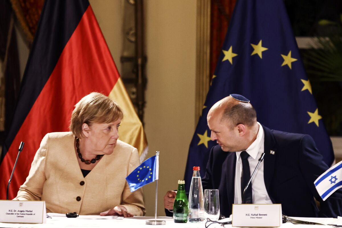 German Chancellor Angela Merkel and Israeli Prime Minister Naftali Bennett chat during a roundtable discussion with Israeli entrepreneurs, in Jerusalem Sunday, Oct. 10, 2021. (Ronen Zvulun/Pool via AP)