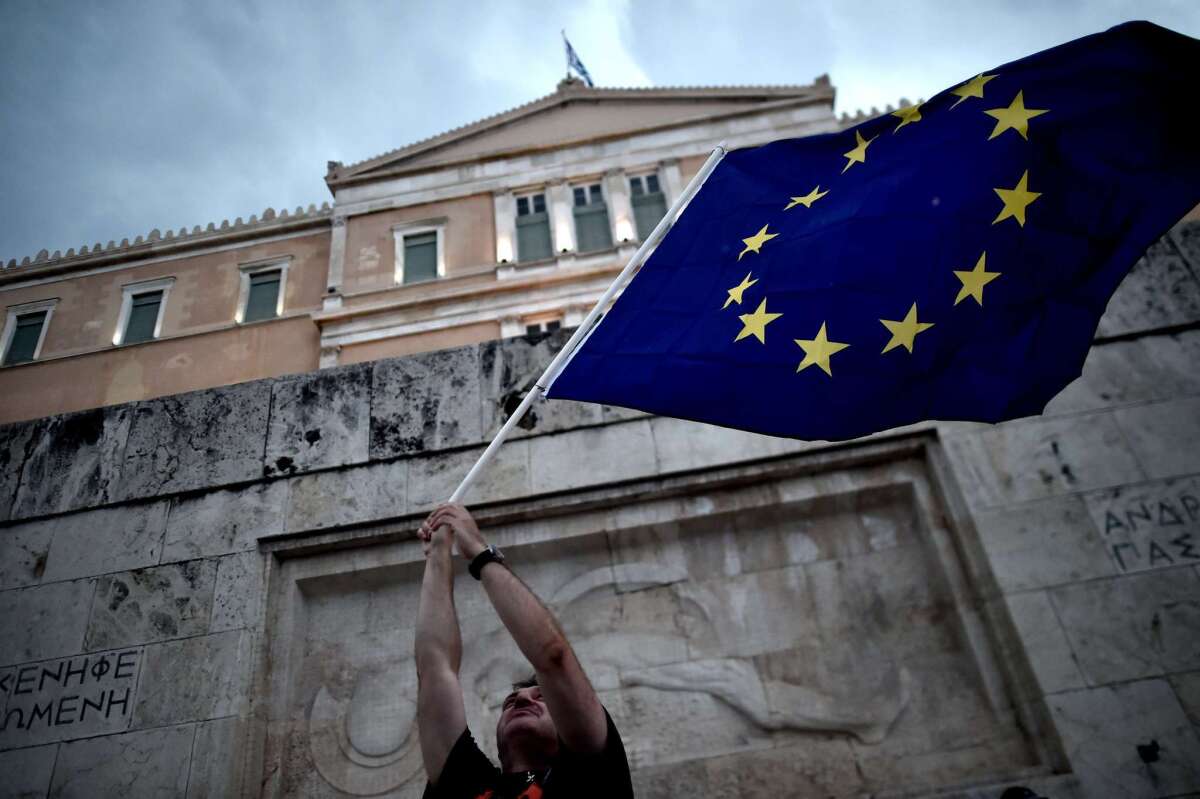 A demonstrator waves a European Union flag during a rally in Athens on June 30 in support of a bailout deal.