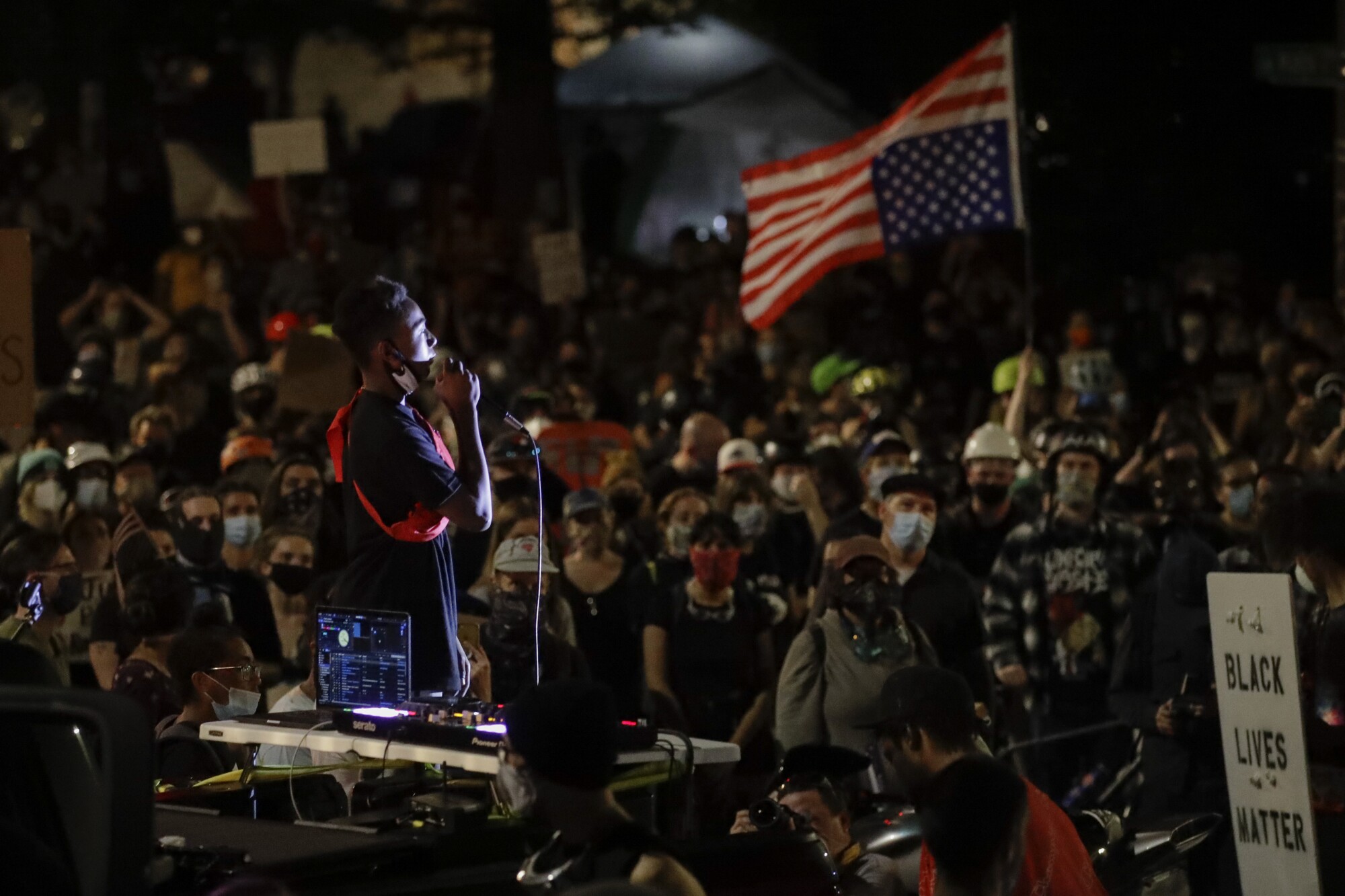 A demonstrator speaks to a crowd from the bed of a pickup truck during a Black Lives Matter protest in Portland, Ore.