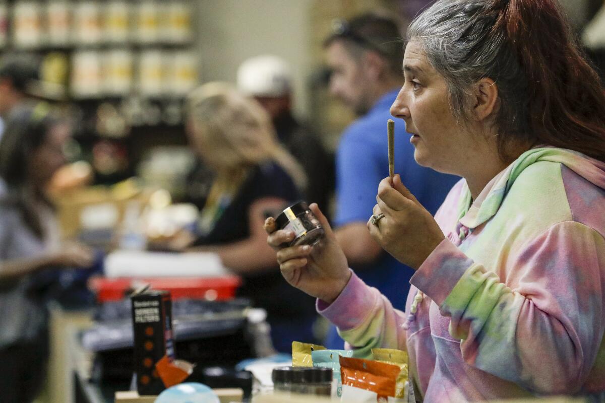 A budtender displays options at a cannabis dispensary 