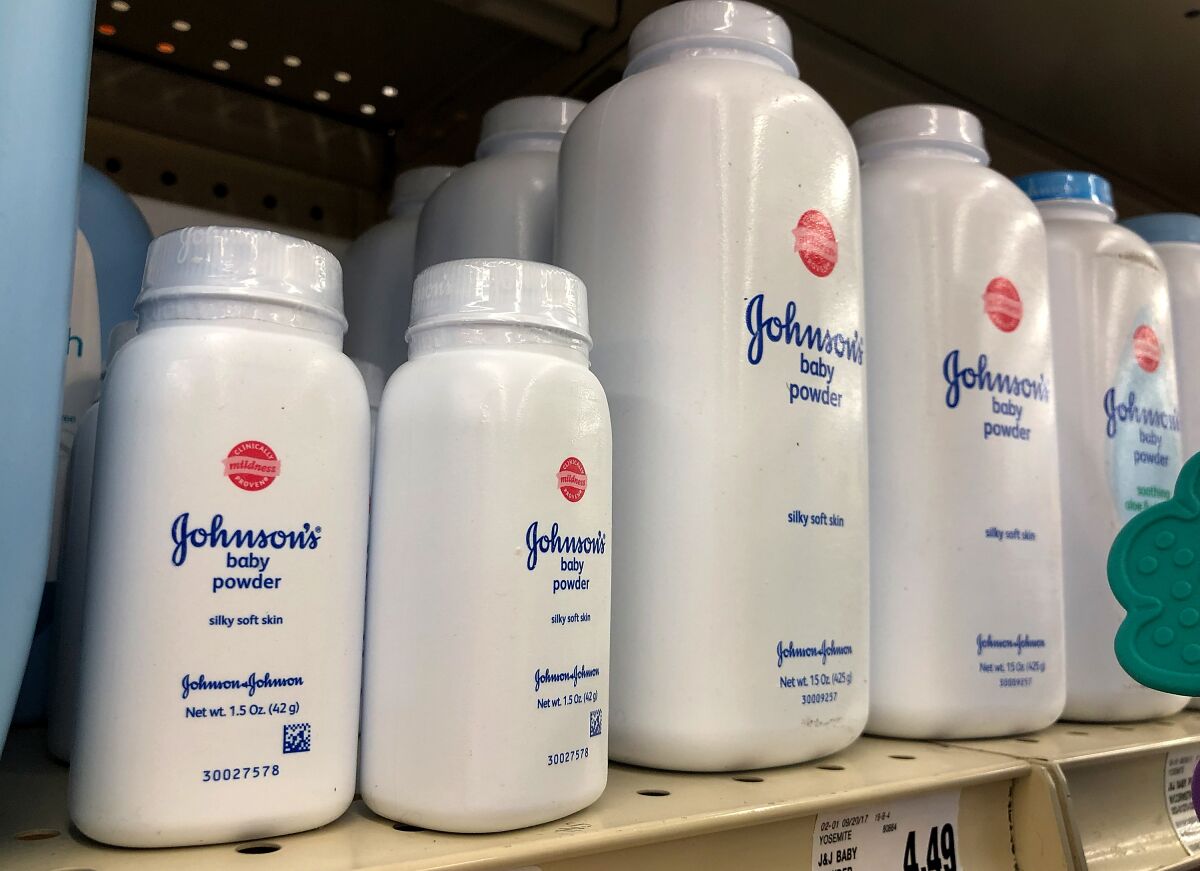 Containers of Johnson's baby powder are displayed on a store shelf 