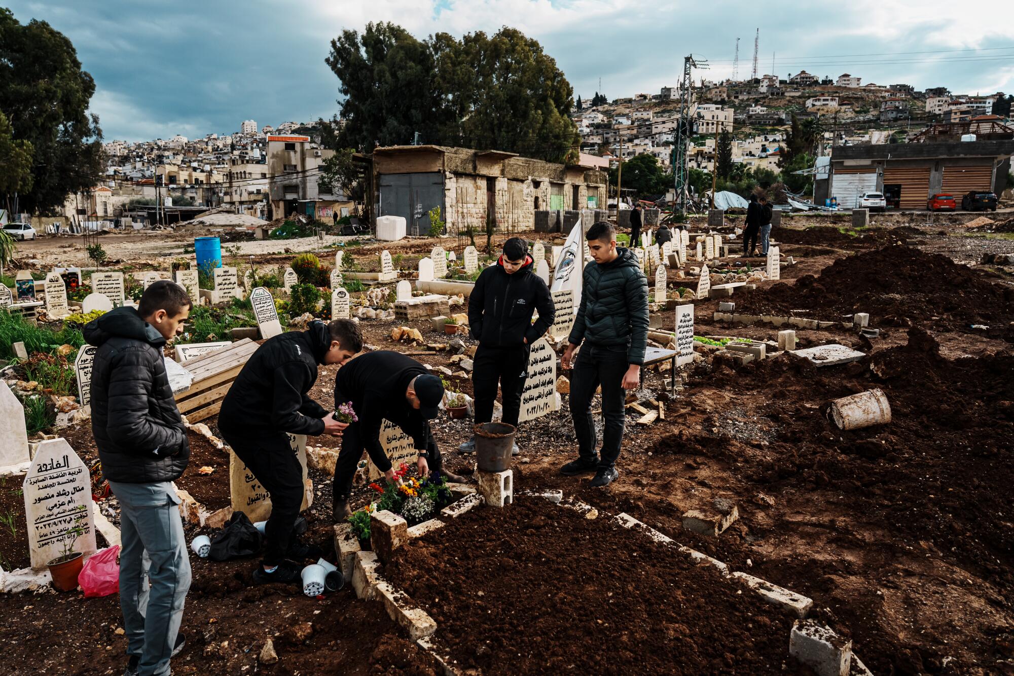 People visit and pay their respects at a grave.