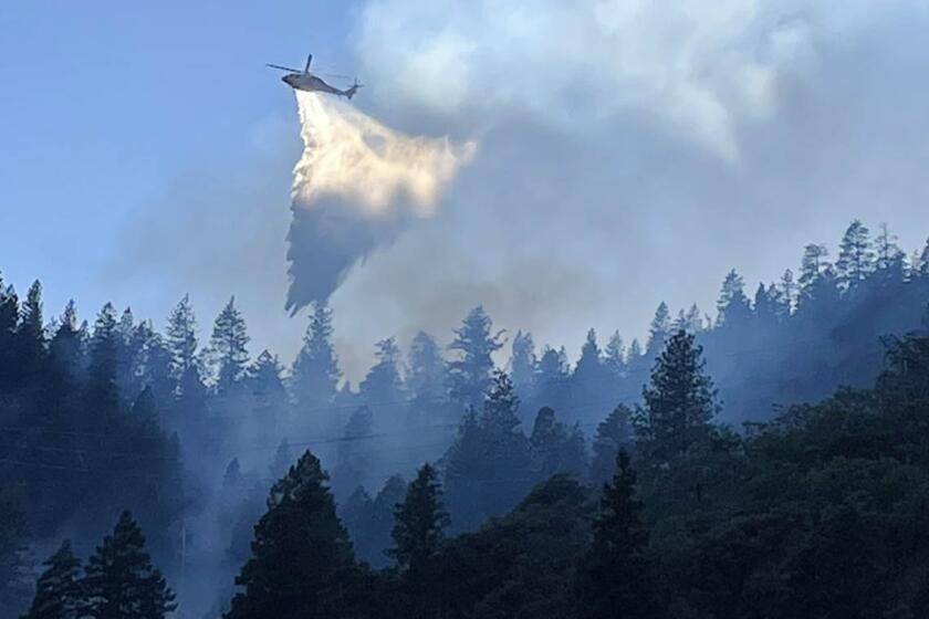 A helicopter makes a water drop on the Dixie fire in Butte County.