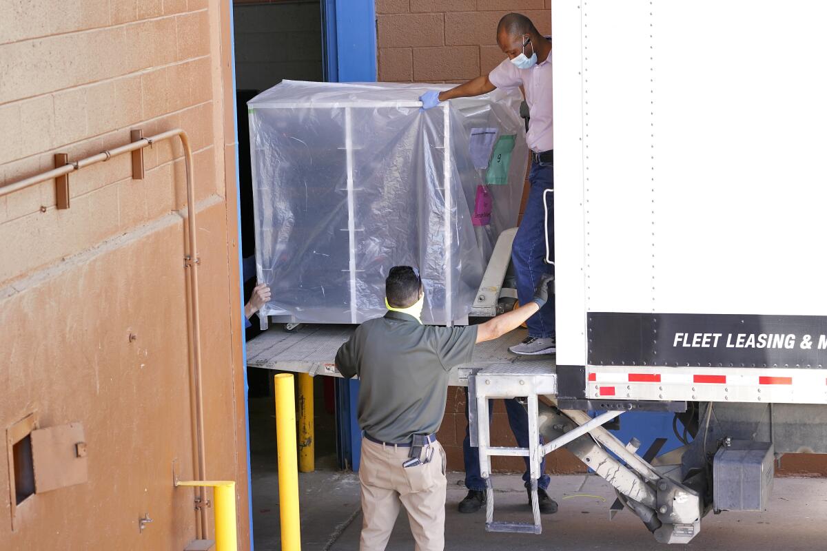 Officials unload election equipment from a truck into the Veterans Memorial Coliseum. ( Photo/)