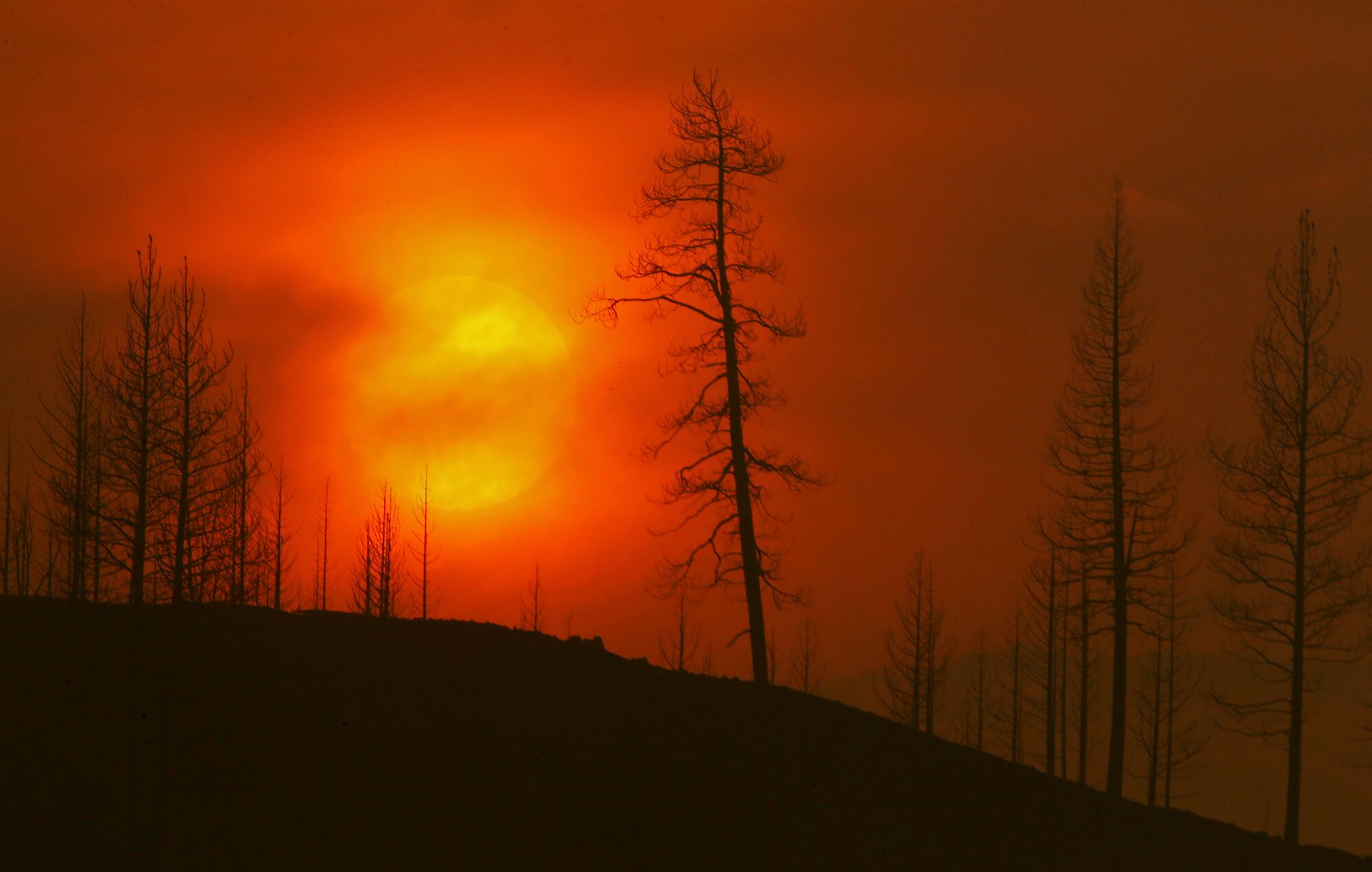 Smoke obscures the sun as it sets on the burn zone of the McKinney fire near Yreka. 