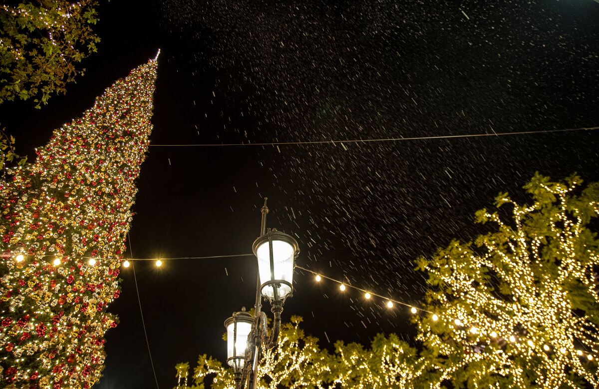 Fake snow falls over the holiday scenes and decorations at The Grove.