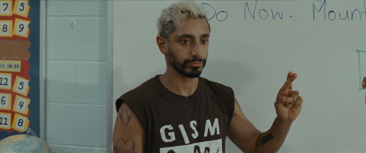 Riz Ahmed crossing his fingers together to sign the letter "R" in "Sound of Metal."