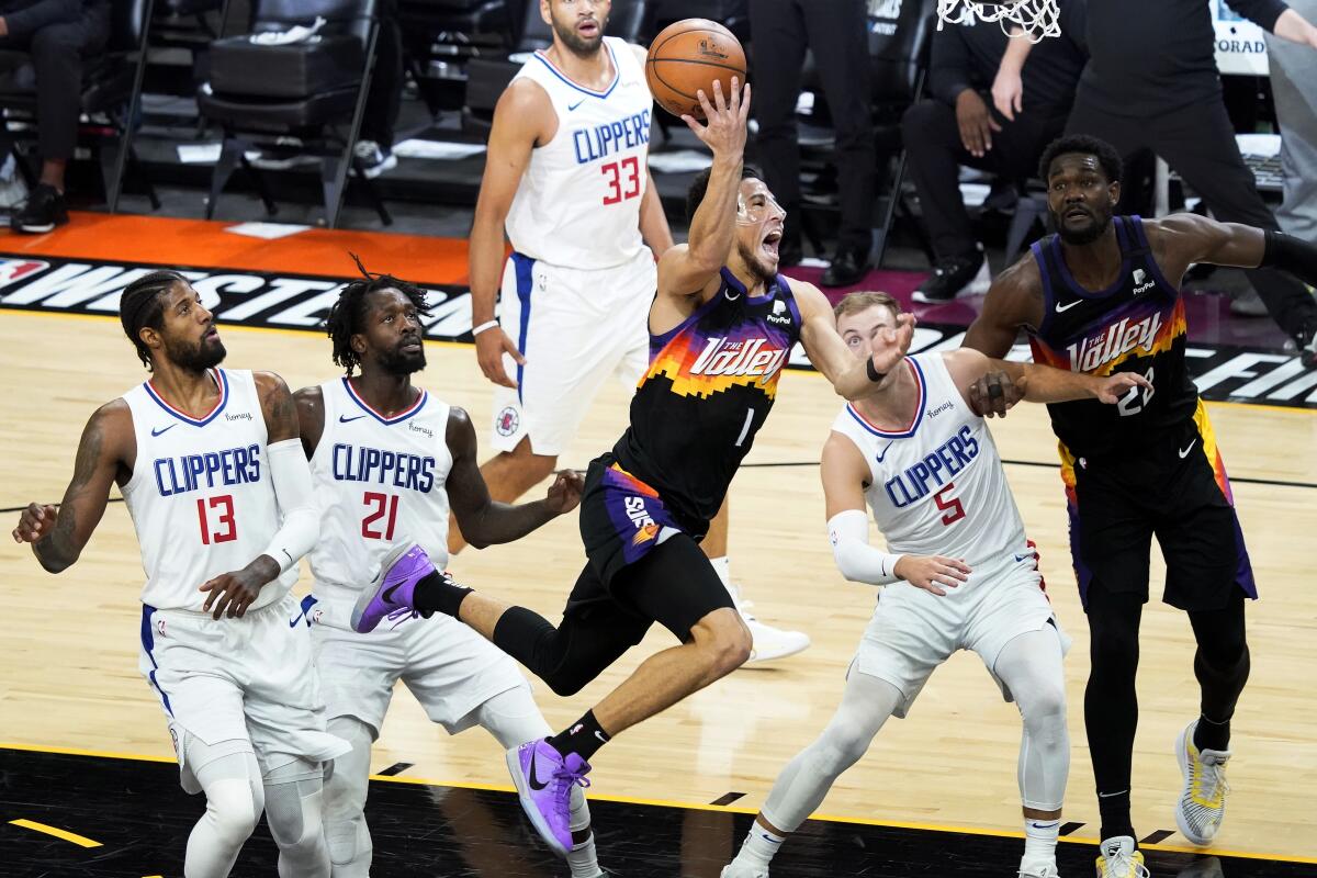 Suns guard Devin Booker is fouled while driving to the basket during Game 5.