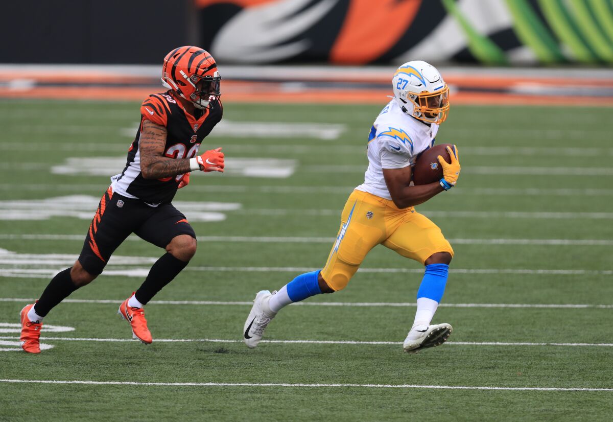 Chargers running back Josh Kelley is chased by Cincinnati Bengals' Jessie Bates.
