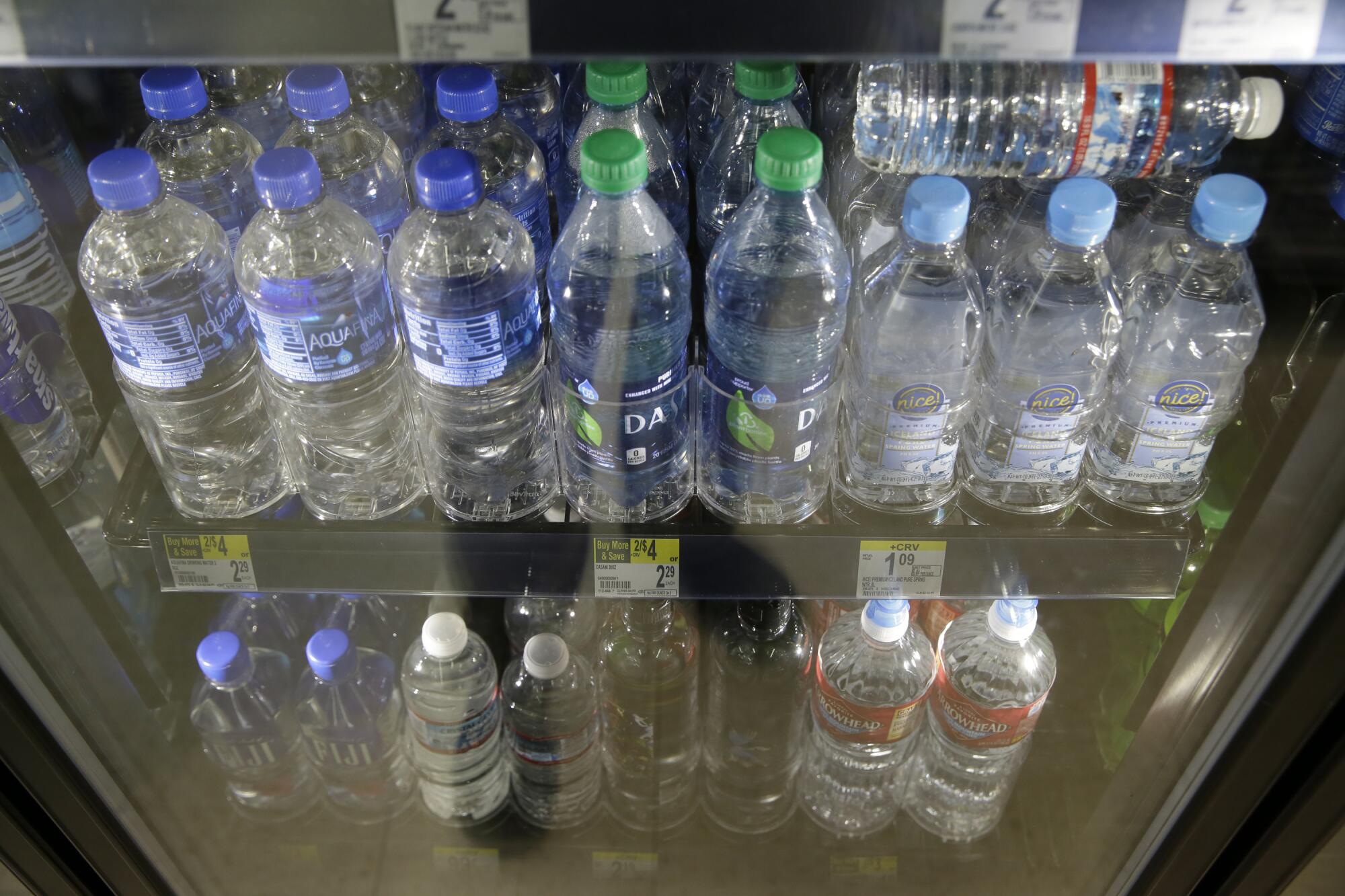 Plastic bottles for sale in a refrigerator.