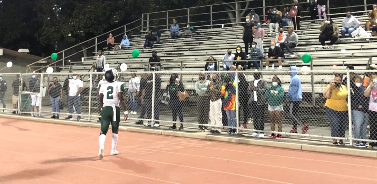 Dorsey quarterback Josh Coleman talks to fans in the stands at Jackie Robinson Stadium on Friday night.