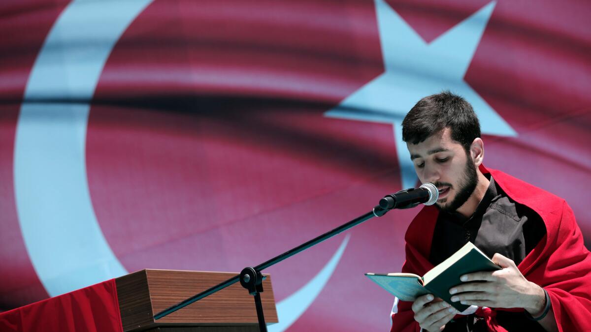 A youth recites from the Quran, Islam's Holy Book, during a pro-government protest against the attempted coup, in Istanbul, Turkey on July 19.