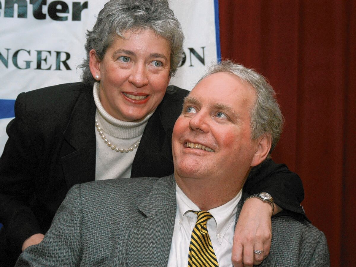 Lucinda Marker throws her arm around her husband, John Tull, at a 2004 news conference in New York. Both were diagnosed with bubonic plague during a 2002 visit to the city.