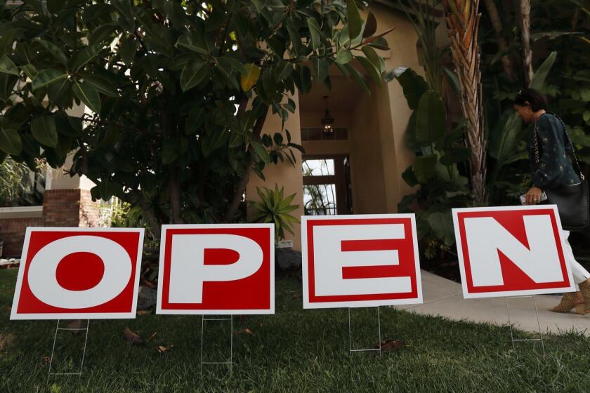 In this Oct. 3, 2018 photo, a woman arrives for an open house in Chula Vista, Calif. A new ballot measure, Proposition 5, would sharply expand a tax benefit for homeowners at least 55 years old and the severely disabled, who wish to transfer their low property taxes when they transition to a new home in the state, if it passes during the Nov. 6 elections. (AP Photo/Gregory Bull)