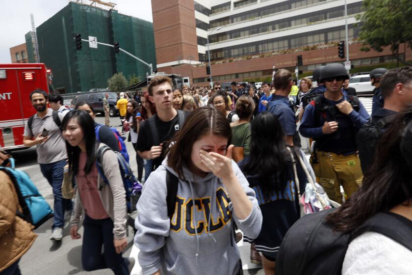 UCLA students evacuate the campus after a shooting Wednesday.