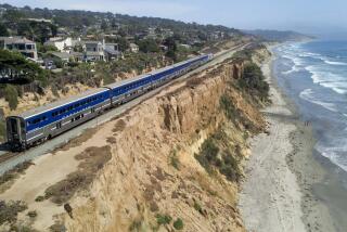 John GibbinsSan Diego Union-Tribune AN AMTRAK Surfliner train travels along the eroding sandstone cliffs in Del Mar. Protecting the busy bluff-top route will cost millions.