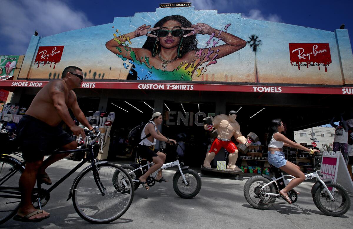 Bicyclists roll down the Venice Beach boardwalk on a warm Thursday afternoon.