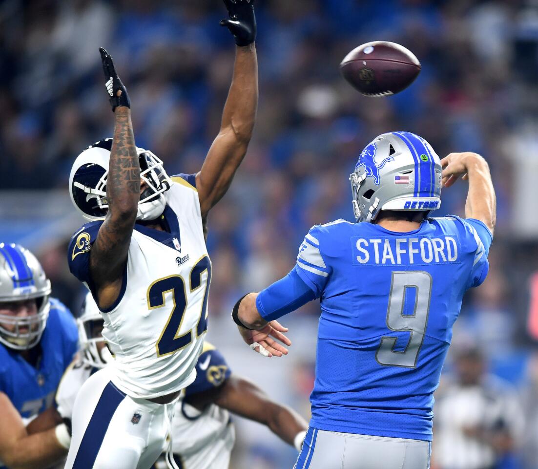 Lions quarterback Matthew Stafford gets a pass off despite defensive pressure from Rams' Marcus Peters invthe first quarter at Ford Field in Detroit on Sunday.