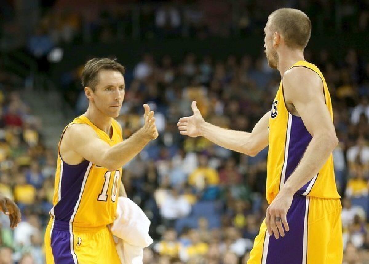 Lakers point guard Steve Nash high-fives teammate Steve Blake as he enters the preseason game against the Trail Blazers.