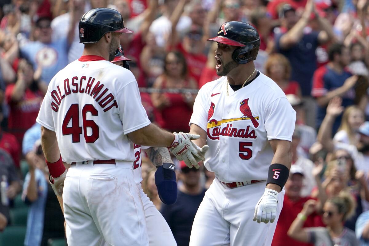 St. Louis Cardinals' Albert Pujols (5) is congratulated by teammate Paul Goldschmidt (46) after hitting a three-run home run during the eighth inning of a baseball game against the Milwaukee Brewers Sunday, Aug. 14, 2022, in St. Louis. (AP Photo/Jeff Roberson)