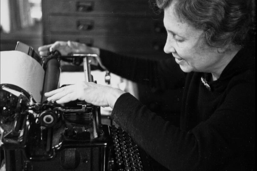 Helen Keller sits at a typewriter