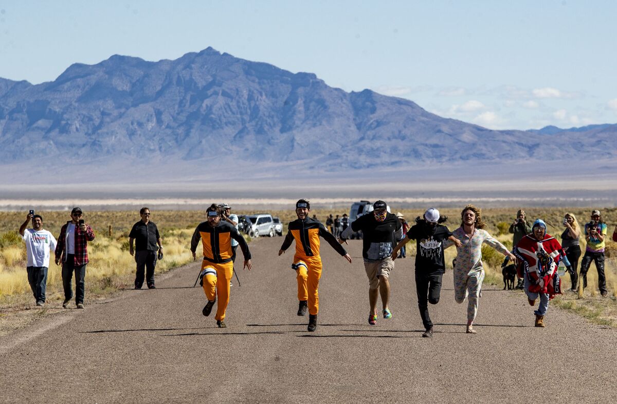 Alien enthusiasts run toward the back gate of Area 51, feigning to storm the gate near the town of Rachel, NV.