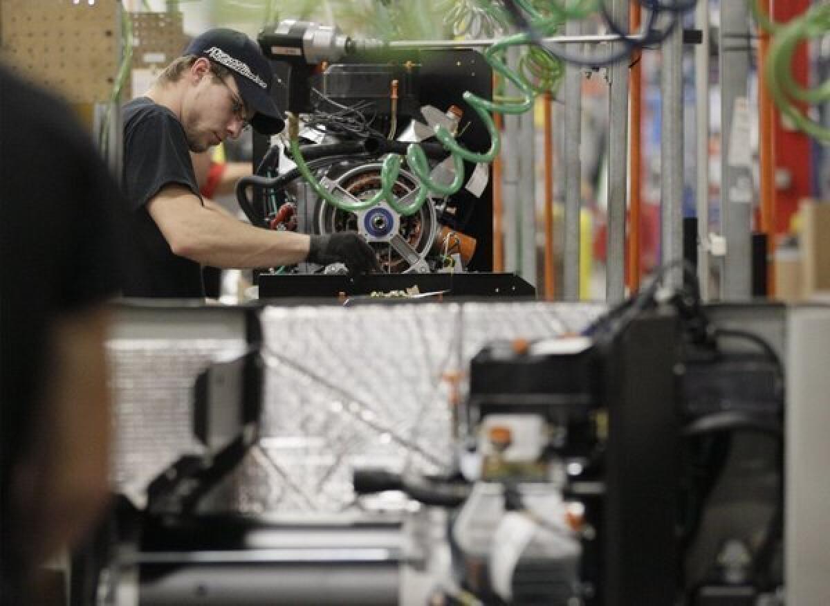 An employee works on an assembly line at Generac Power Systems Inc. in Whitewater, Wis.